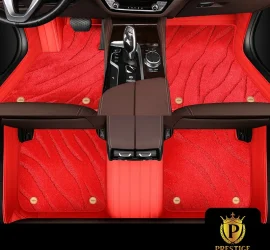 Onyx Red custom car floor mats in bright red wave-textured carpet with a matching red leather surround and gold badge studs